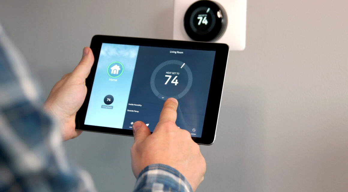 Person controlling thermostat temperature through tablet